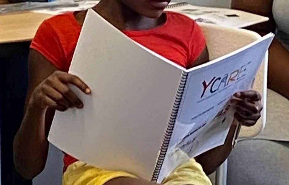 A young girl reading a book in a Global Neuro Ycare classroom.